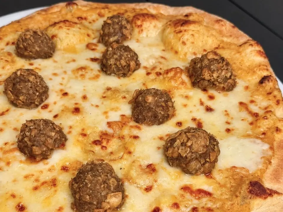 Una pizza bianca con le polpette appena sfornata