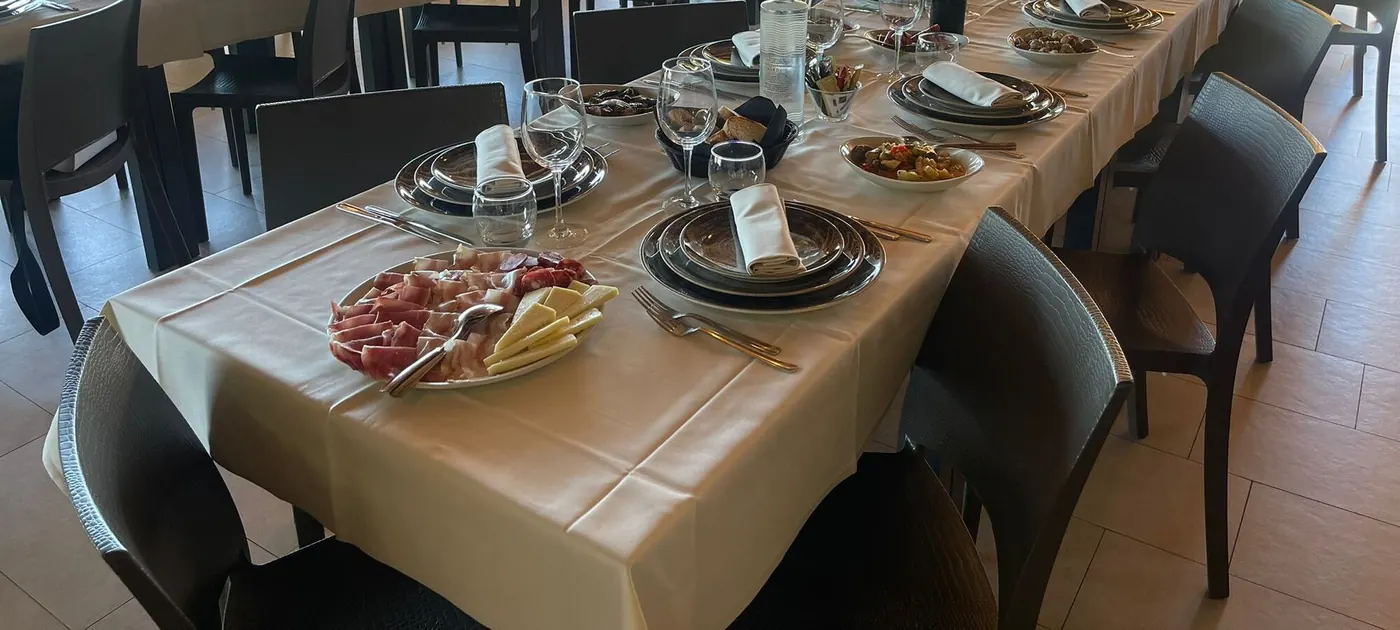 La sala di Bardy's apparecchiata per una tavolata, con un tagliere di salumi e formaggi in primo piano